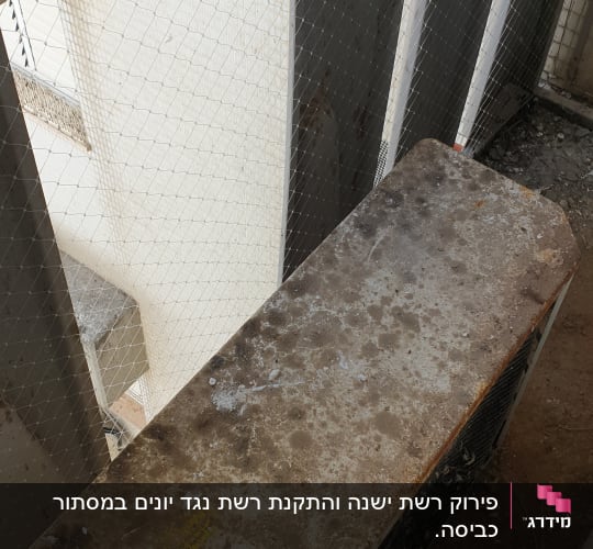 יחידת מזגן חיצונית ישנה ומלוכלכת עם רשת הגנה
